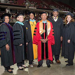 College president and board members in graduation robes