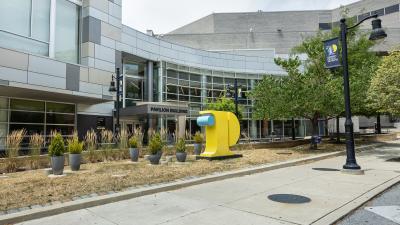 Exterior view of Pavilion Building with 3D College logo icon in forefront