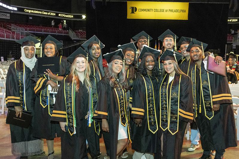 15 or so students posing at commencement 2024 