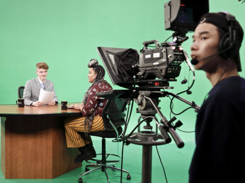 Students on CCPTV set together at the news while the camera operator discusses the next shot