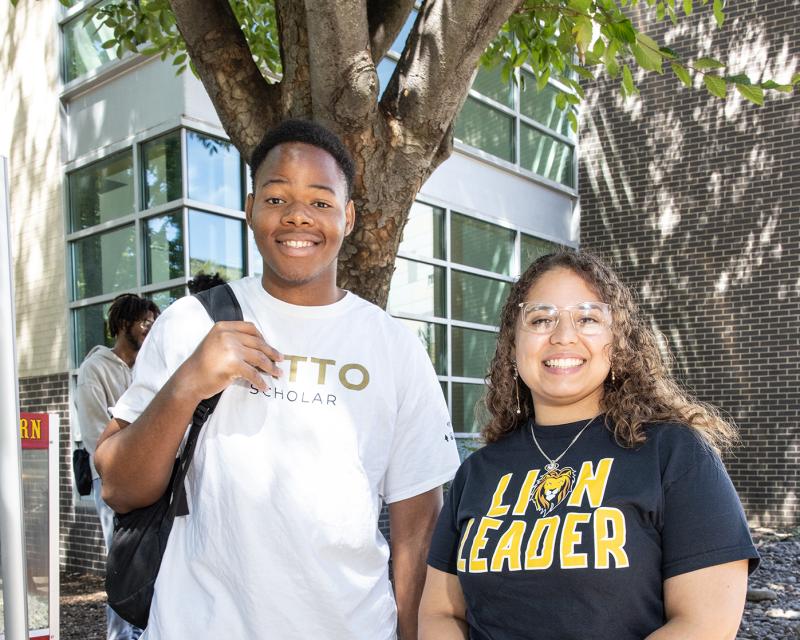 Two students smiling outside in the courtyard
