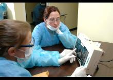  Dental Hygiene students looking at x-ray in clinic at CCP.